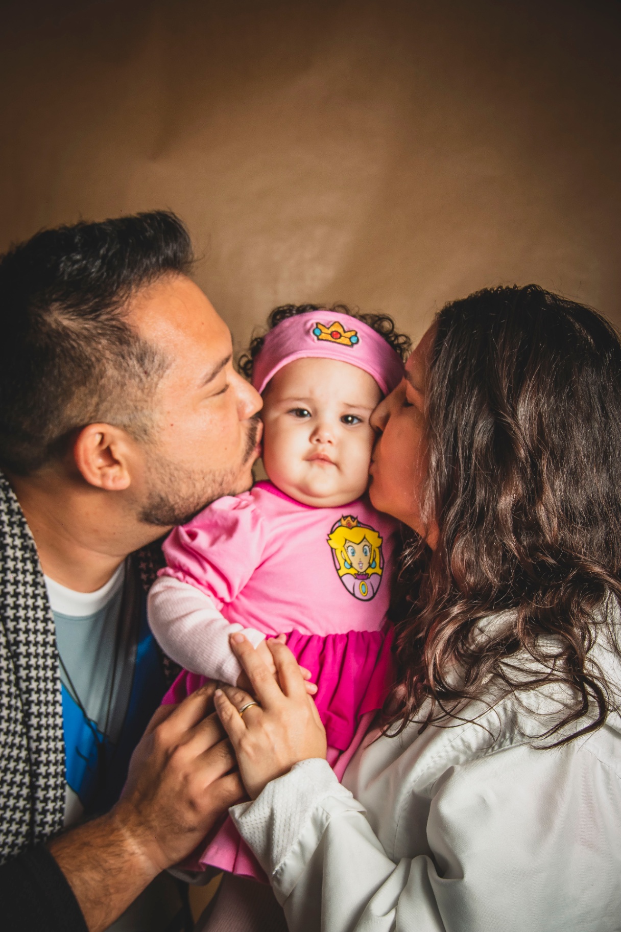 Matsu e esposa beijando a bochecha da filha